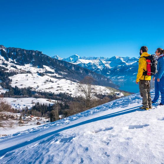 Ein Paar wandert in der stimmungsvollen Winternatur und bewundert die verschneite Naturkulisse