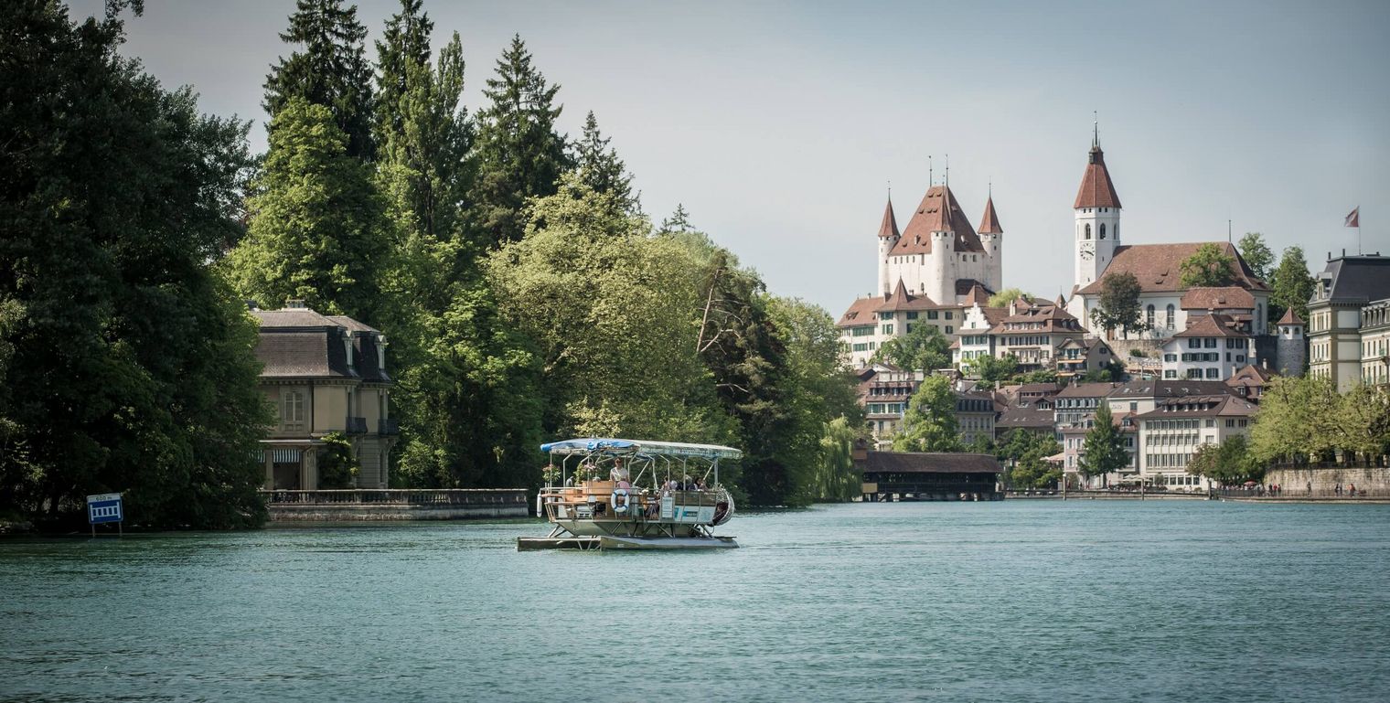 Shuttlefahrt mit dem Solarschiff führt vom Thunersee via Aare in die Stadt Thun – Blick auf Schloss Thun inklusive