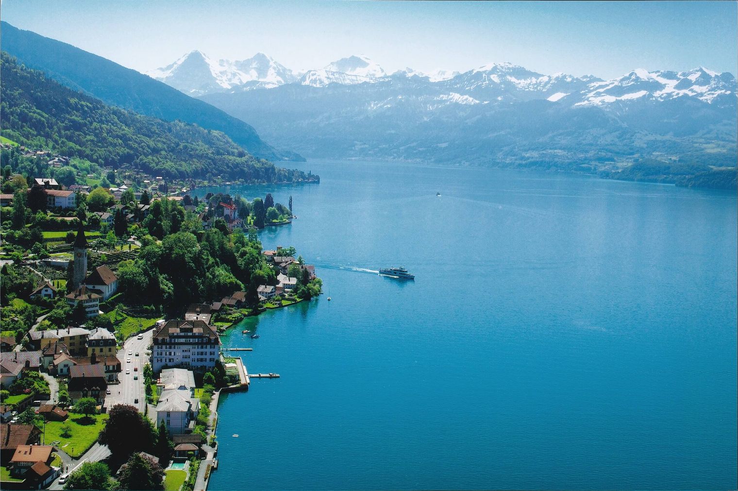 Luftaufnahme vom Hotel Restaurant Bellevue au Lac mit Thunersee und Berge