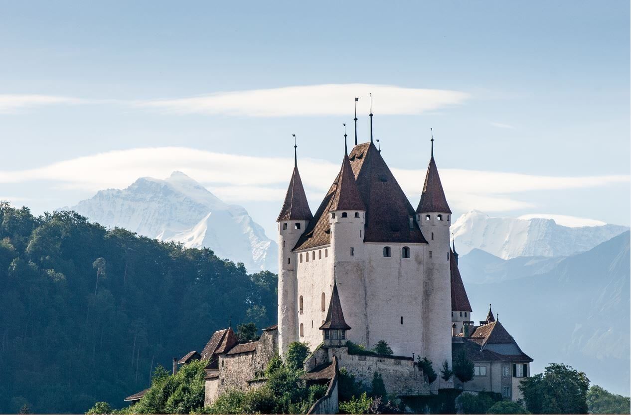 Schloss Thun mit Bergen im Hintergrund