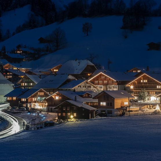 Schön beleuchtete Häuser in einer klaren Winternacht im Diemtigtal