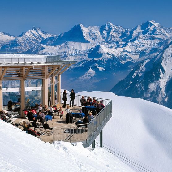 Panoramarestaurant umgeben von weissem Schnee mit Blick auf die Berge im Berner Oberland