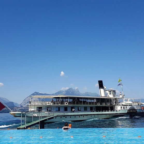 Aussicht vom Pool im Strandbad Merligen mit einem Schiff auf dem Thunersee