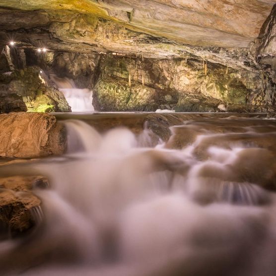 Beleuchteter Wasserfall in den St. Beatus-Höhlen bei Beatenberg