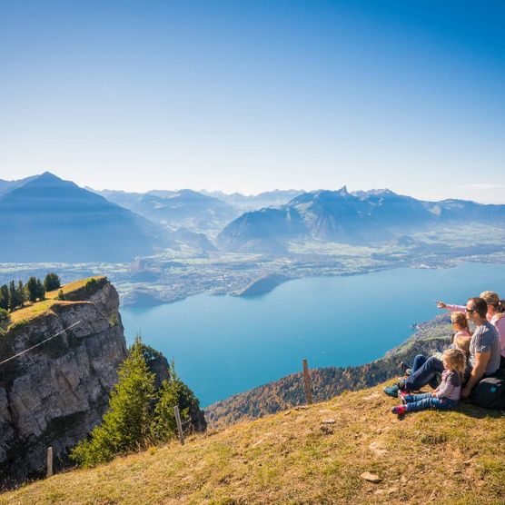 Die Familie geniesst die rundum Aussicht vom Niederhorn auf den Thunersee und die Berge