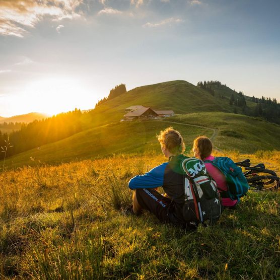 Zwei Biker ruhen sich während dem Sonnenuntergang auf der Lombachalp aus